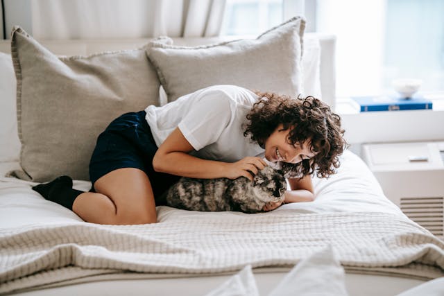 a person lying in bed with a cat