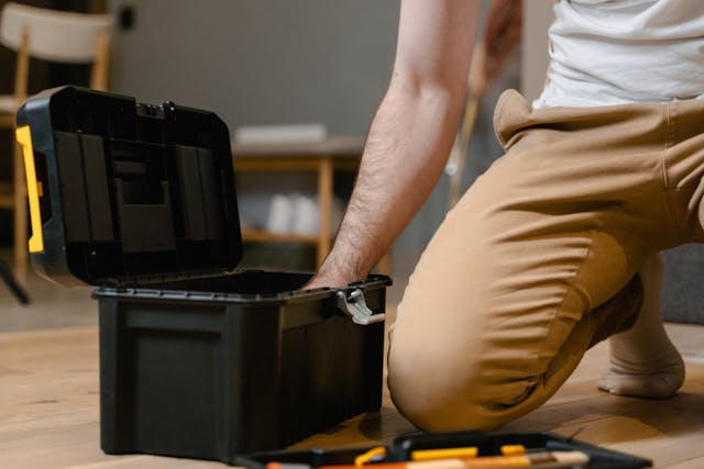 a person with an open toolbox on the floor
